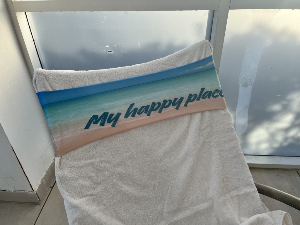 Side view of a tcboo sun lounger towel band fitted around the backrest