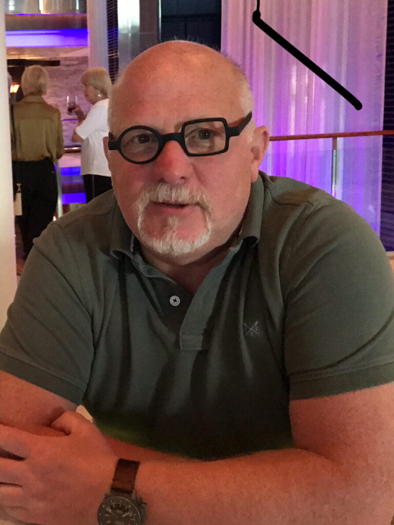 Jon MacLeod, founder of tcboo, seated aboard a cruise ship