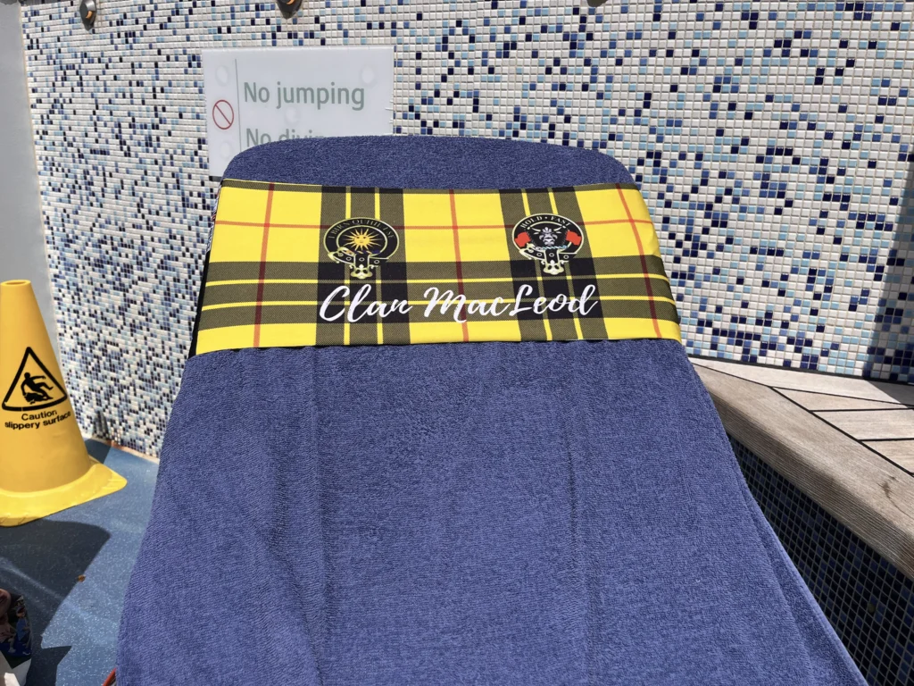 blue towel secured to a sun lounger by a yellow tartan tcboo towel band
