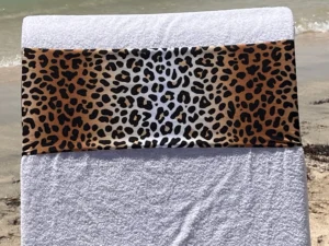 Leopard print tcboo sun lounger towel band securing a beach towel