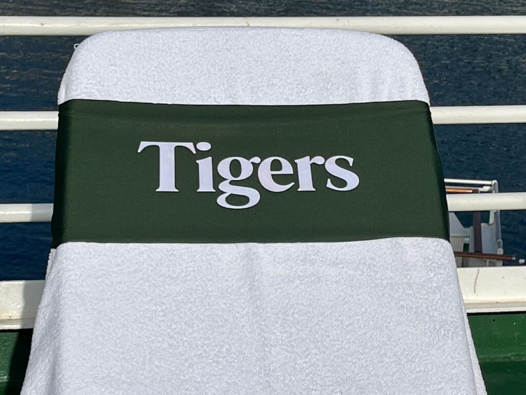 Tigers in white on a green tcboo sun lounger band securing a towel to a sun lounger