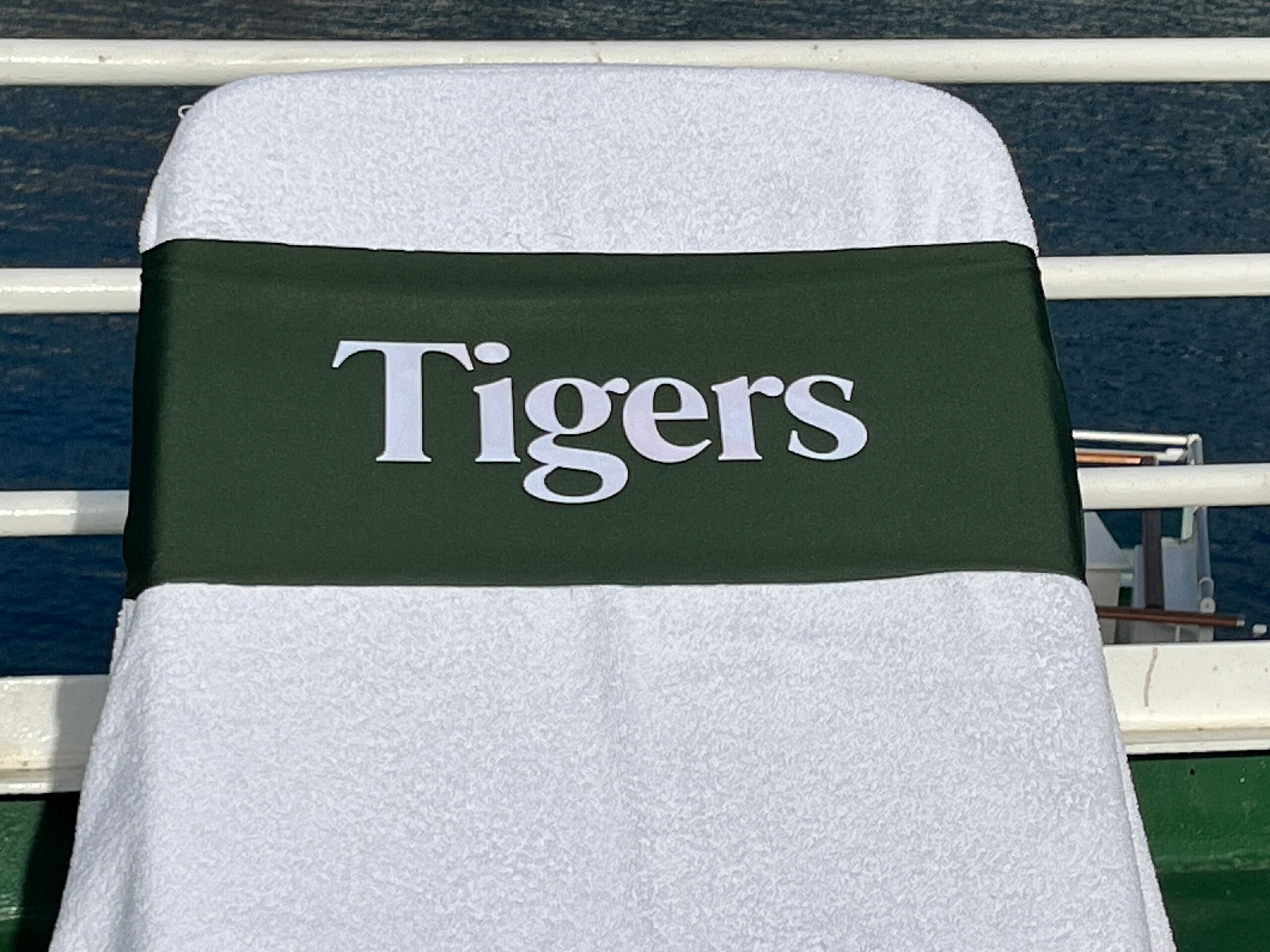 Tigers in white on a green tcboo sun lounger band securing a towel to a sun lounger
