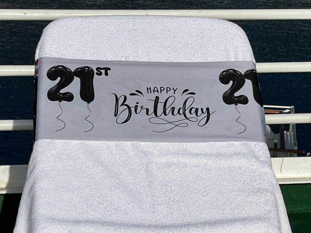 21st Birthday silver tcboo sun lounger band securing a towel to a sun lounger