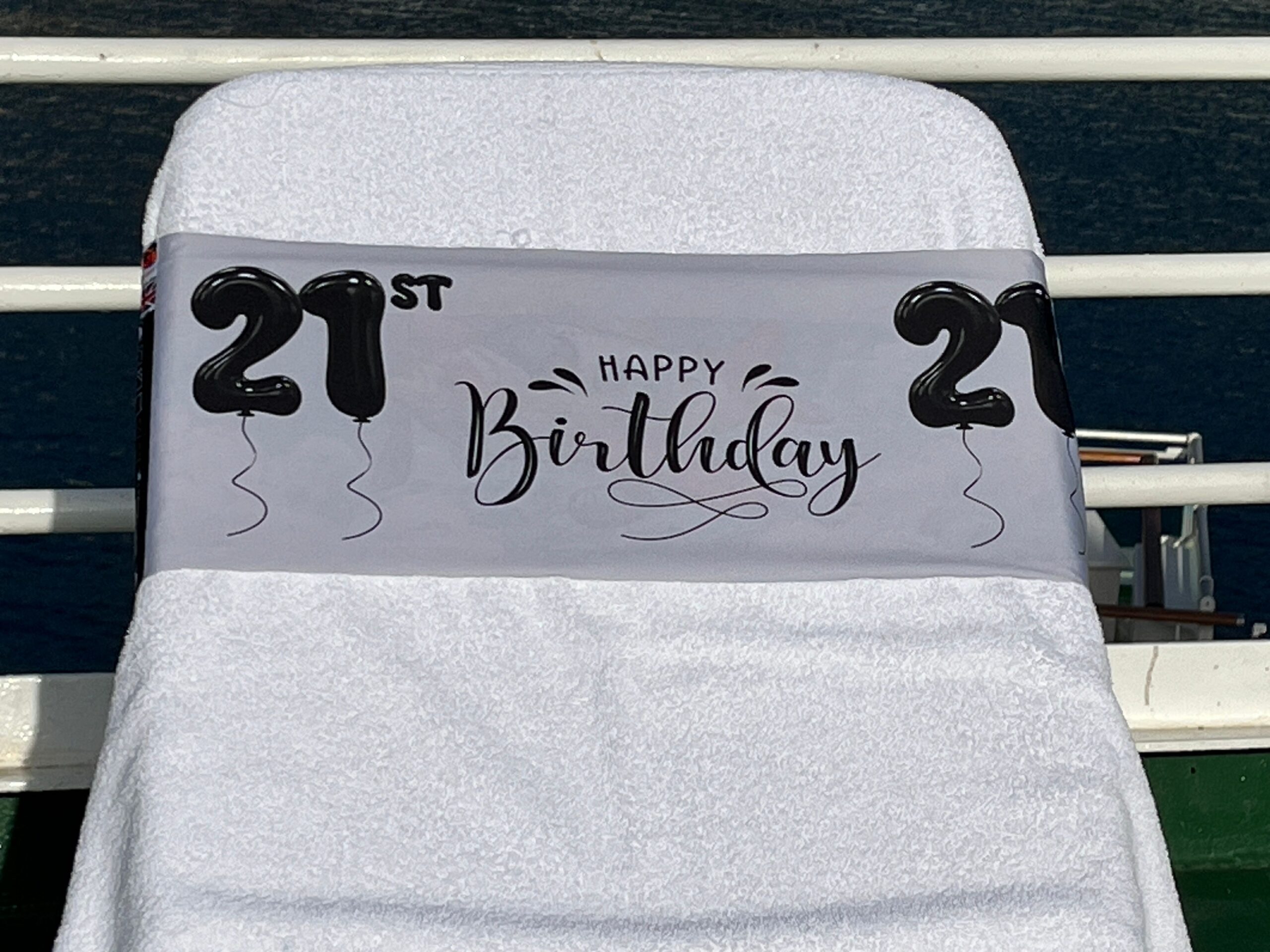 21st Birthday silver tcboo sun lounger band securing a towel to a sun lounger