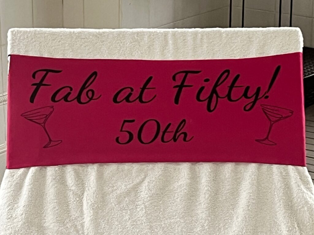 Fab at 50 cerise-pink tcboo sun lounger band securing a towel to a sun lounger