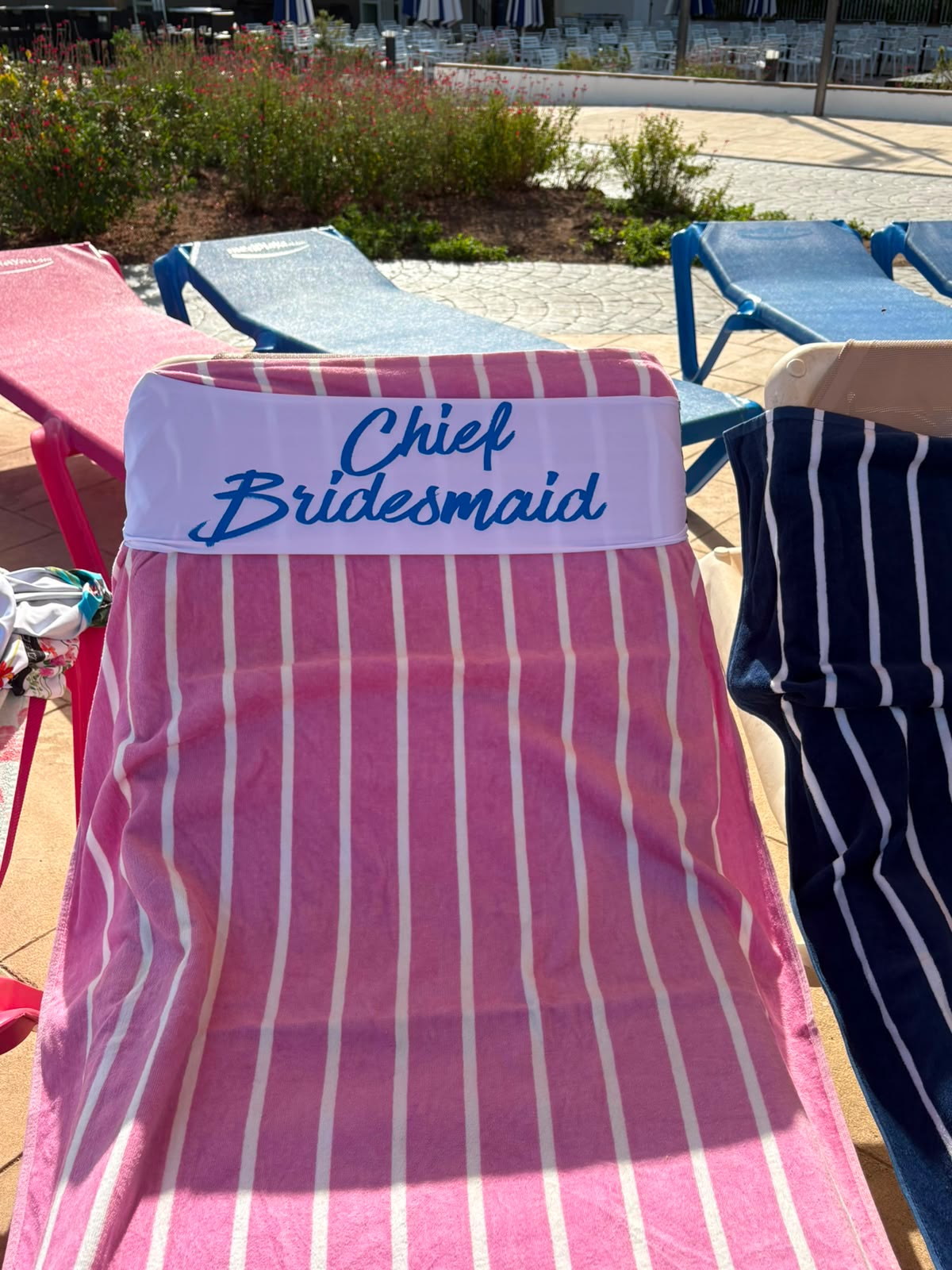 Chief Bridesmaid tcboo sun lounger towel band securing a pink striped towel