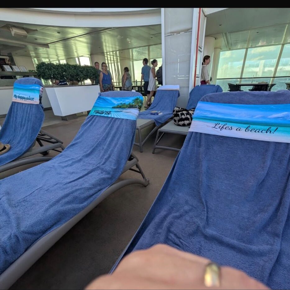 Three tcboo sun lounger towel bands securing blue towels aboard a cruise ship
